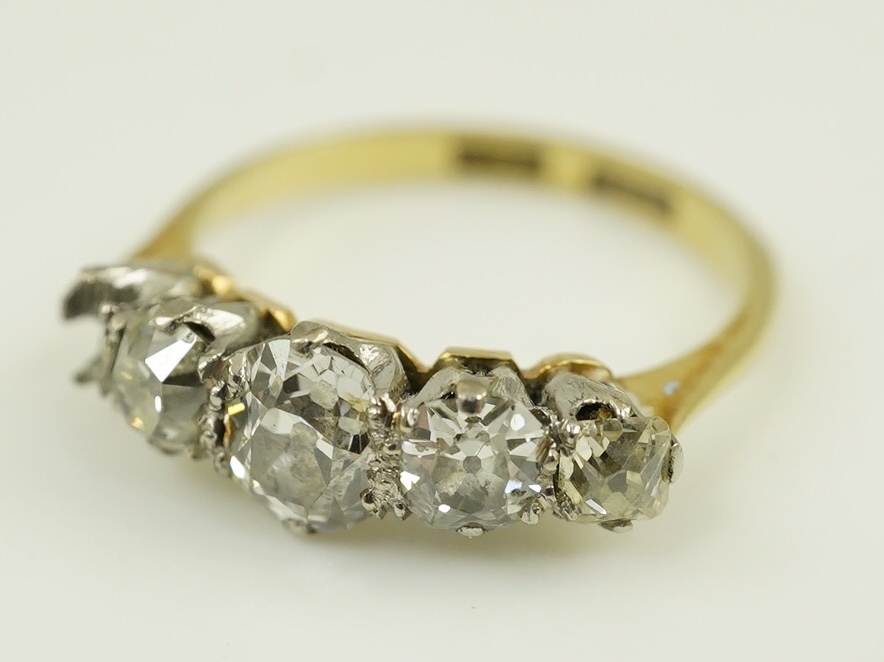 An early 20th century 18ct gold, platinum and graduated five stone old mine cut diamond set half hoop ring(one stone missing)